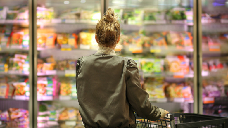 Person in a frozen food aisle at a grocery store