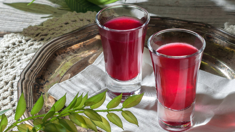 Two shot glasses filled with cherry red alcohol