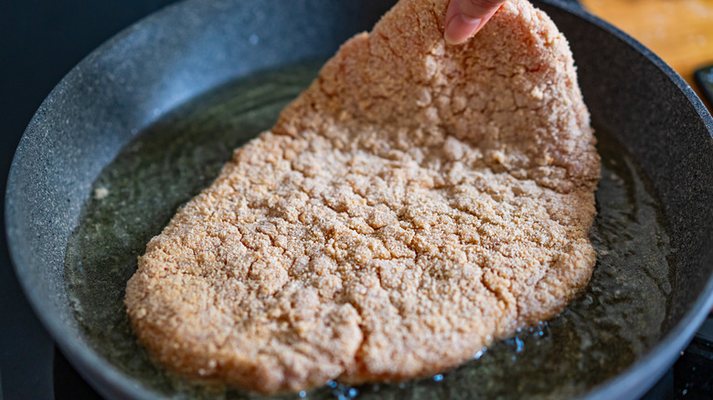 Breaded pork chop in a frying pan
