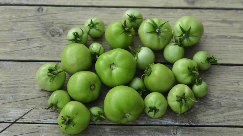 Green tomatoes on wooden background