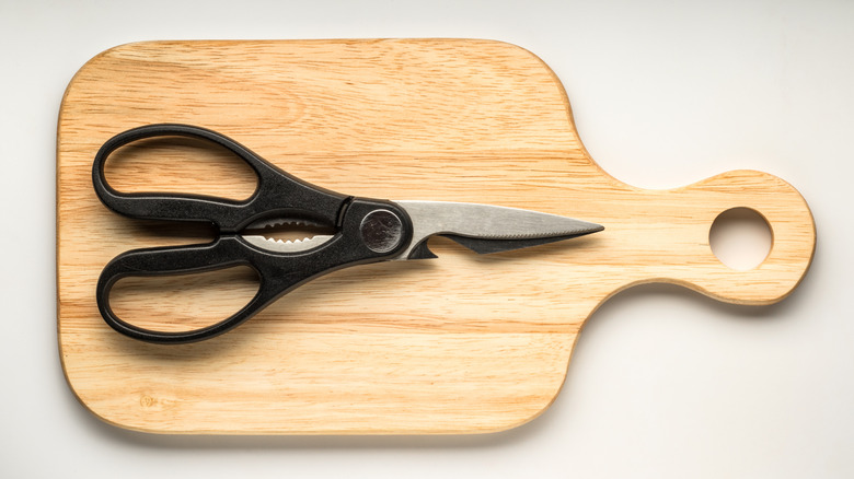 A pair of kitchen sears placed on a wooden cutting board