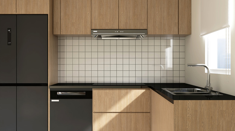 A clean kitchen with wood-finish cabinets and a tile backsplash.