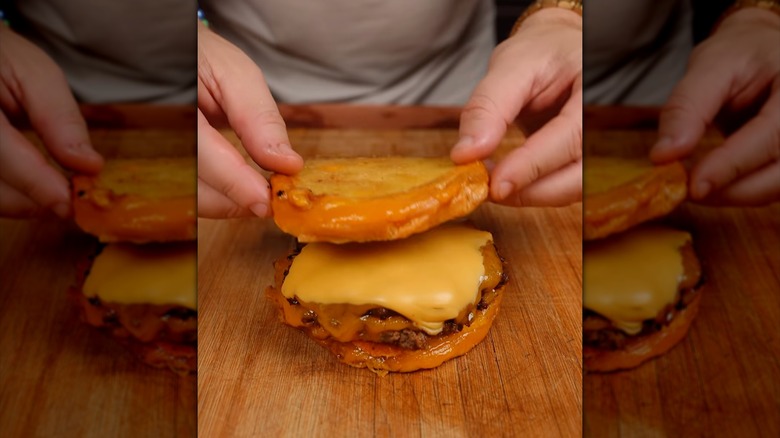Grilled cheese cheeseburger on cutting board.