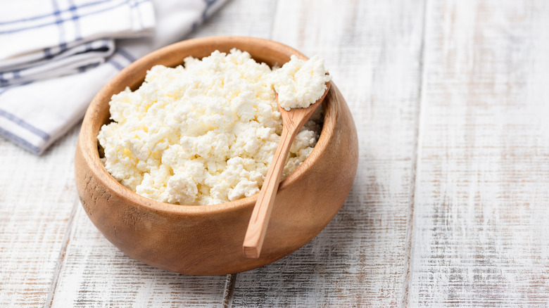 Pressed cottage cheese in wooden bowl.