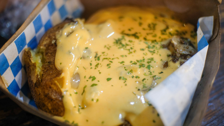 cheese soup on a jacket potato sprinkled with herbs
