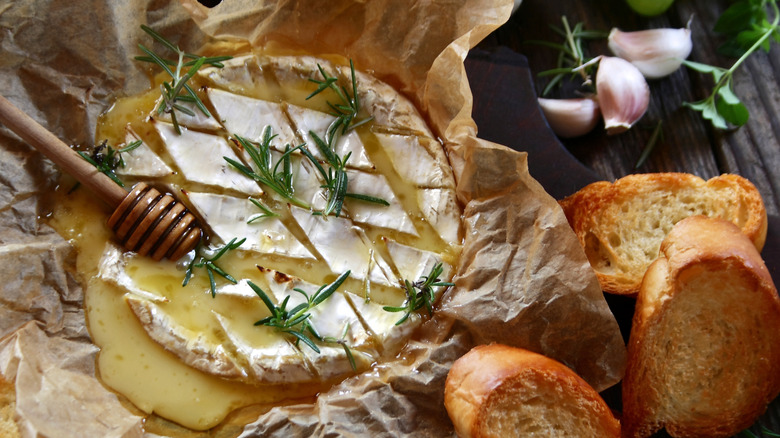 baked brie drizzled in honey with a rosemary sprig