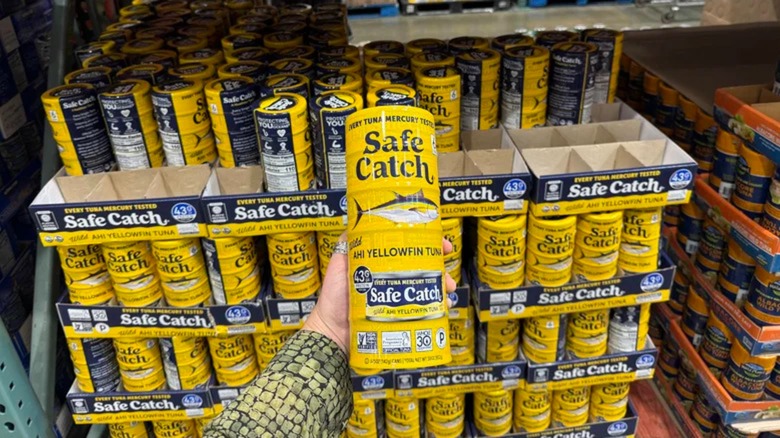 Holding cans of Safe Catch tuna in Costco