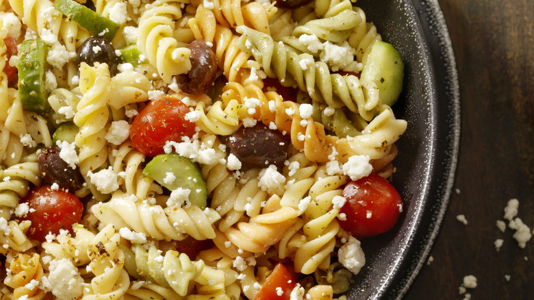 Pasta salad in a bowl with olives and tomatoes
