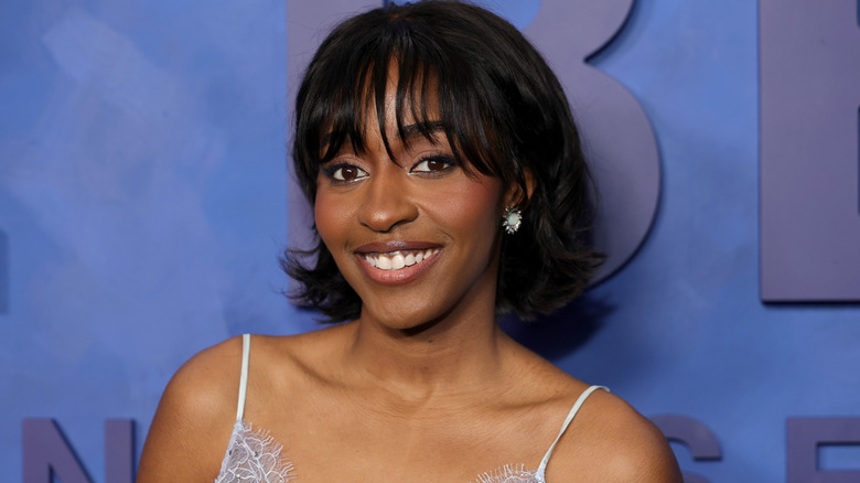 Actress Ayo Edebiri in front of a blue wall.