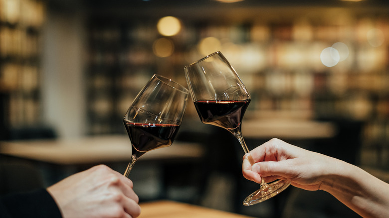 Two glasses of red wine clinking