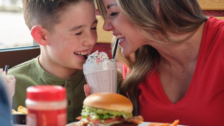 Mother and son sharing a milkshake at Red Robin