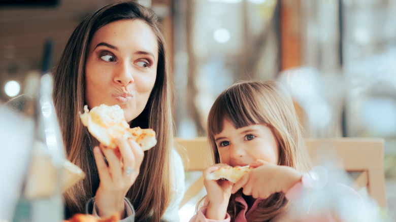 Mom and daughter eating pizza at a restaurant