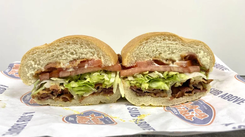 A Jersey Mike's BLT cut in half on wrapping paper.