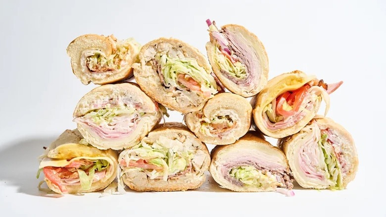 Several sub club sandwiches styled in a stack.