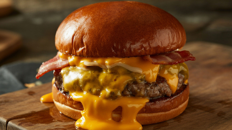 Cheese melts from the sides of a burger.