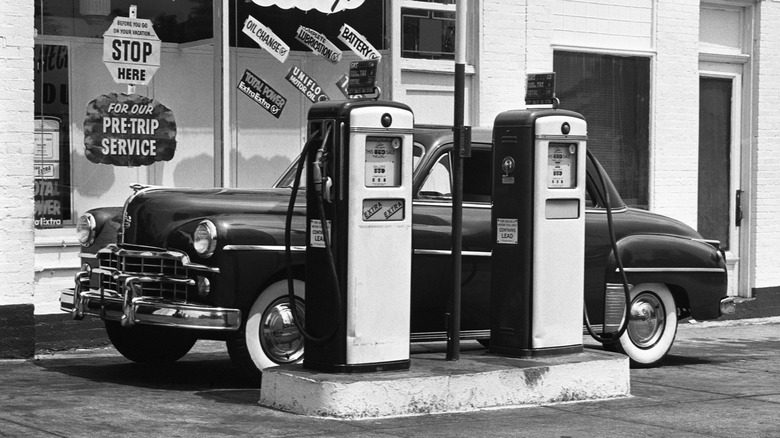 Black and white photo of a 1950s gas station with a car
