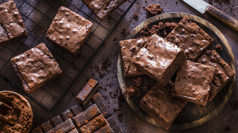 Homemade chocolate square brownies served on a wooden plate