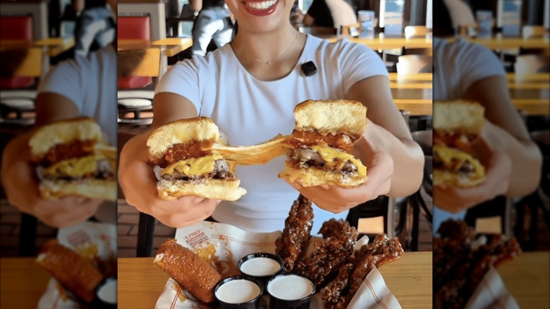 Woman holding the Chili's Big Mouth Bites with one Nashville hot fried mozzarella being pulled apart