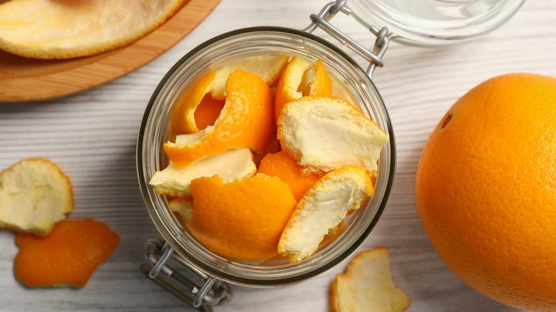 Orange peels in glass jar on table
