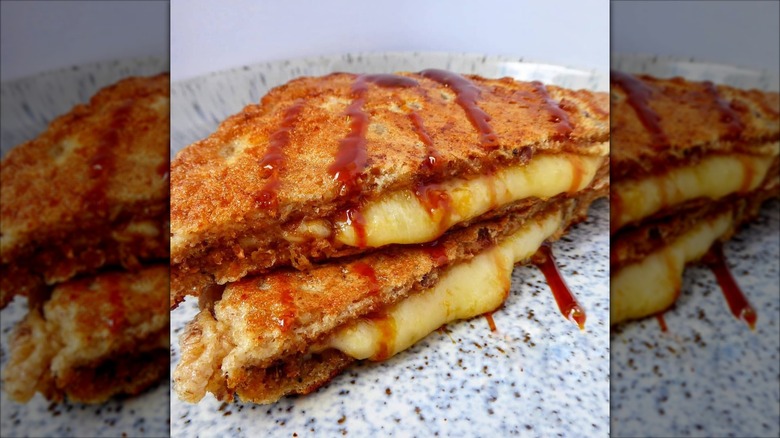 A cheese and Marmite French toast sandwich on a speckled plate