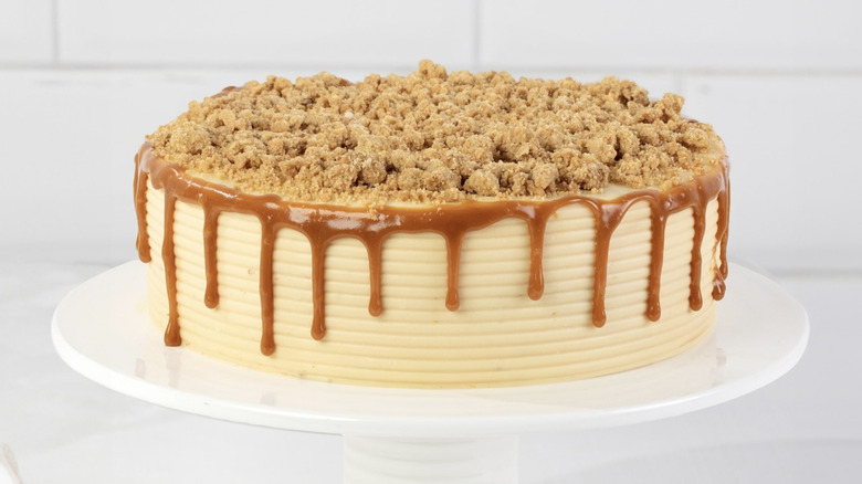 Caramel cake on display with caramel drizzle and streusel on top