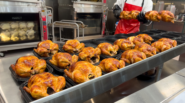 A Costco worker packaging cooked rotisserie chickens.