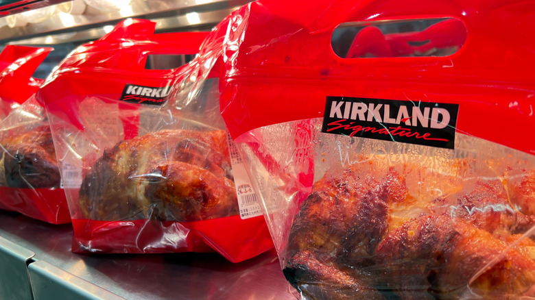 A group of Costco rotisserie chickens in plastic bags.