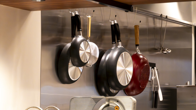 Pans hanging on hooks to increase vertical storage in the kitchen