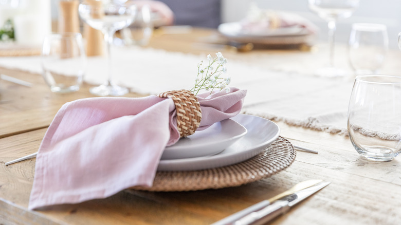 elegant place setting with a pink napkin
