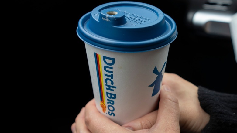 Hands holding a cup of coffee from Dutch Bros