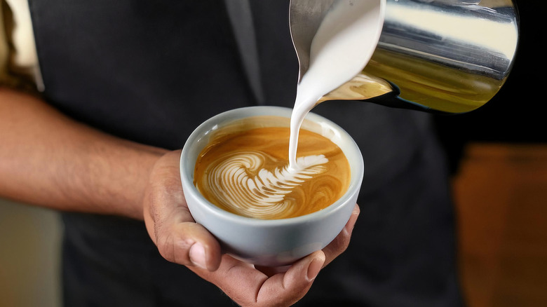 Barista making a cup of coffee latte art