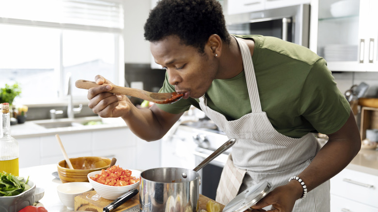 person tasting tomato sauce