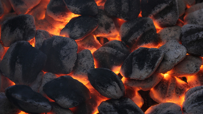 many charcoal briquettes glowing in a barbecue.