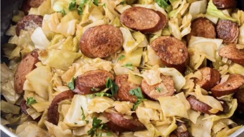 cabbage and sausage cooking in a skillet