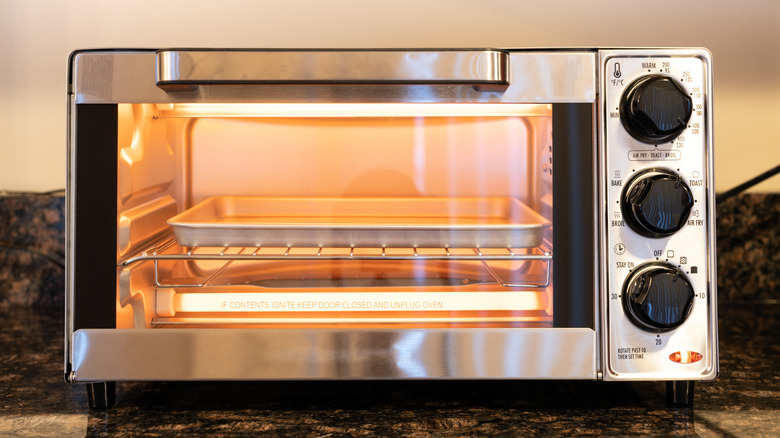 A warmed up toaster oven with a tray inside