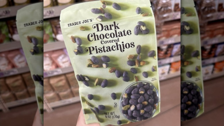 Person holding a bag of Trader Joe's Dark Chocolate Covered Pistachios
