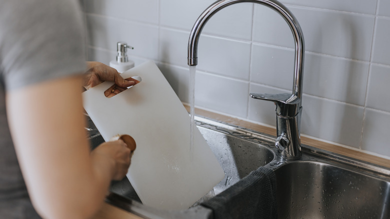 Washing a cutting board in a sink
