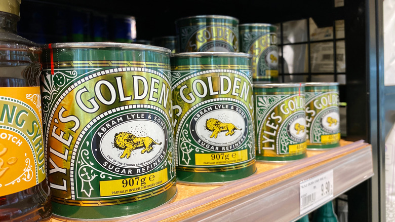Cans of Lyle's Golden Syrup on a shelf