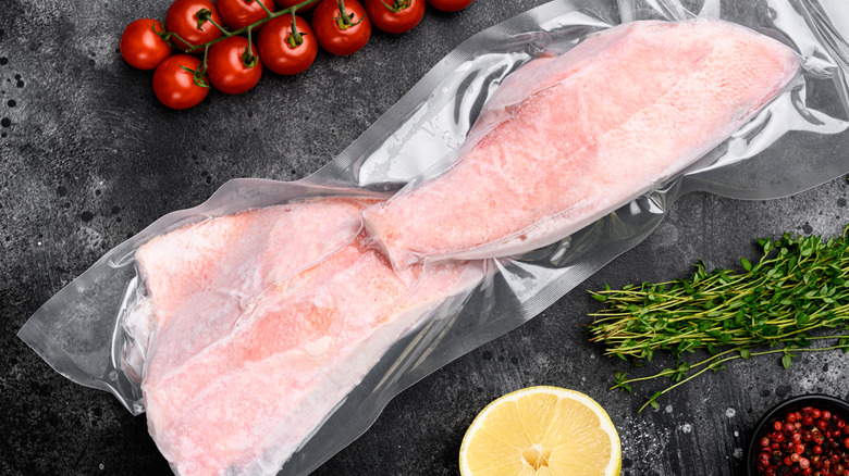 Frozen red snapper fillets with lemon, cherry tomatoes, and herbs on the side