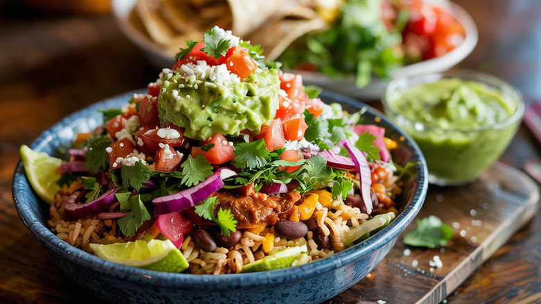 a burrito bowl piled high with guacamole and other toppings