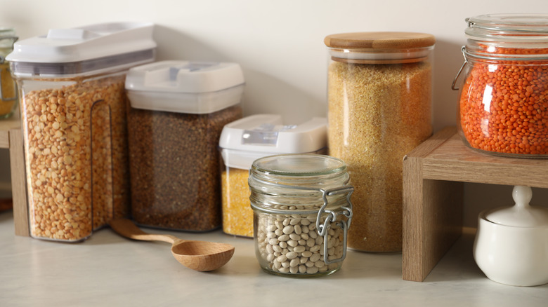 Cereal and beans and flour in glass containers in kitchen