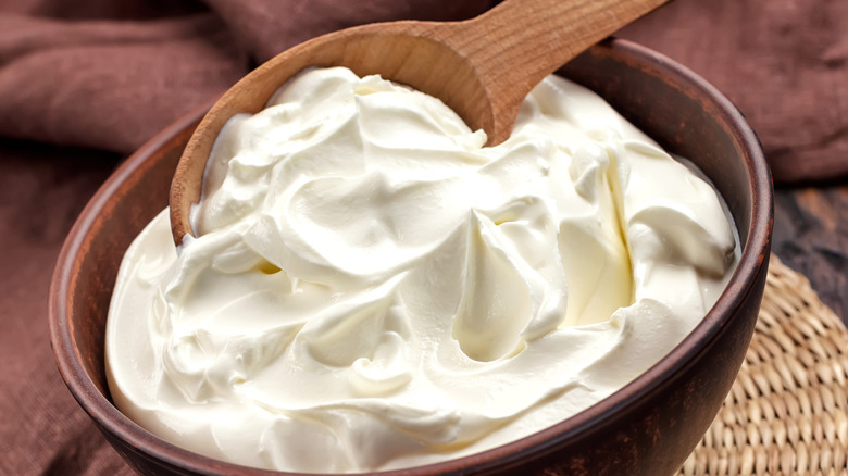Whipped cream cheese in a bowl with a wooden spoon