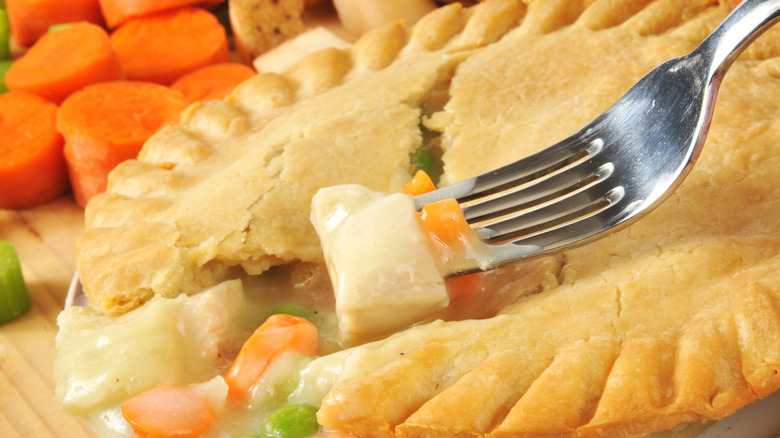 A fork taking a piece of potato out of a chicken pot pie