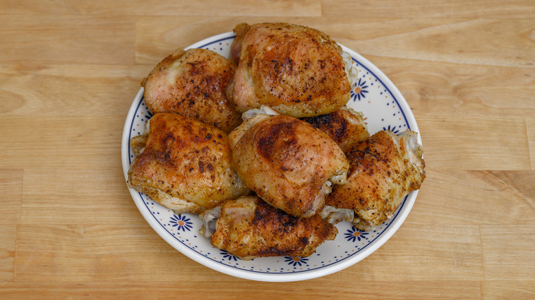 Crispy golden chicken thighs stacked on a plate