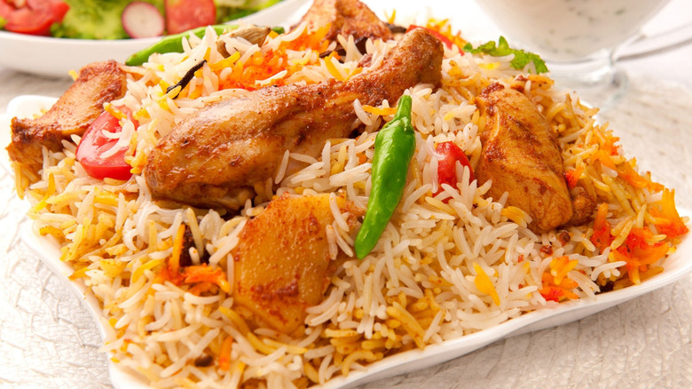 A plate piled high with chicken biryani and basmati rice