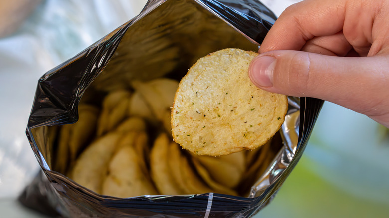 Hand pulling spiced chip from bag