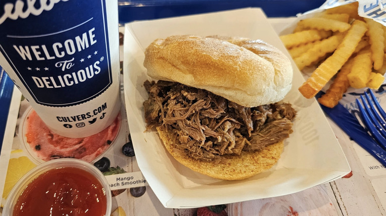 Culver's pot roast sandwich on a tray with fries, ketchup, and a drink