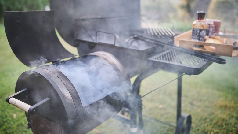 A barbecue with smoker box emitting smoke