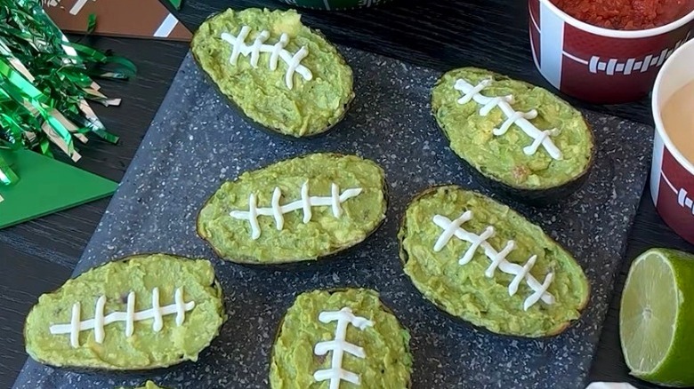 Guacamole served in avocado shells decorated as footballs
