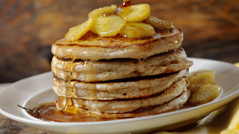 stack of pancakes with fruit and syrup